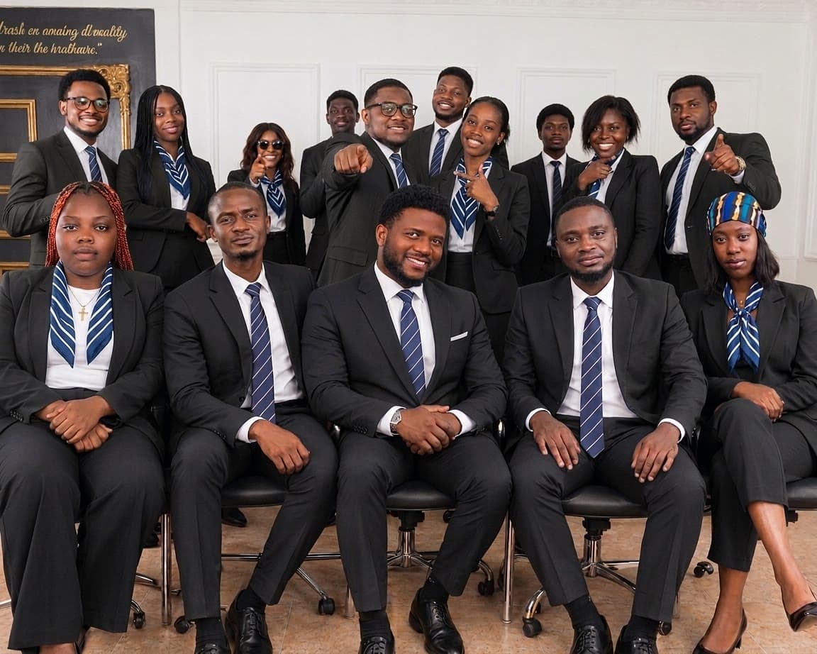 The Reginel Consulting team in dark suits with striped scarves and ties, smiling and pointing towards the camera